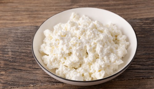 Bröseltopfen in weißer Schüssel auf Holztisch