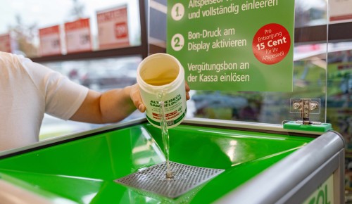 Altspeiseöl wird in einem SPAR Markt im Altöl-Abfall entfernt 