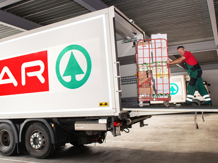 Mitarbeiter schiebt Wagen in einen SPAR LKW
