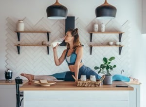 Frau in Yogapose, die frühstückt