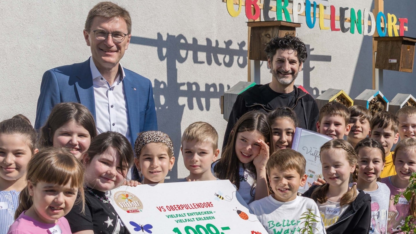 Die Schüler:innen der Volksschule Oberpullendorf mit SPAR-Geschäftsführer Alois Huber und Sternekoch Paul Ivić beim Hochbeet im Schulgarten, das Teil des ausgezeichneten Vielfaltspreis-Projekts ist.