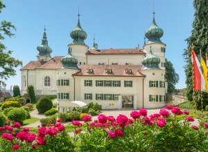 Außenaufnahme des Schloss Artstetten mit pinken Pfingstrosen an einem sonnigem Tag