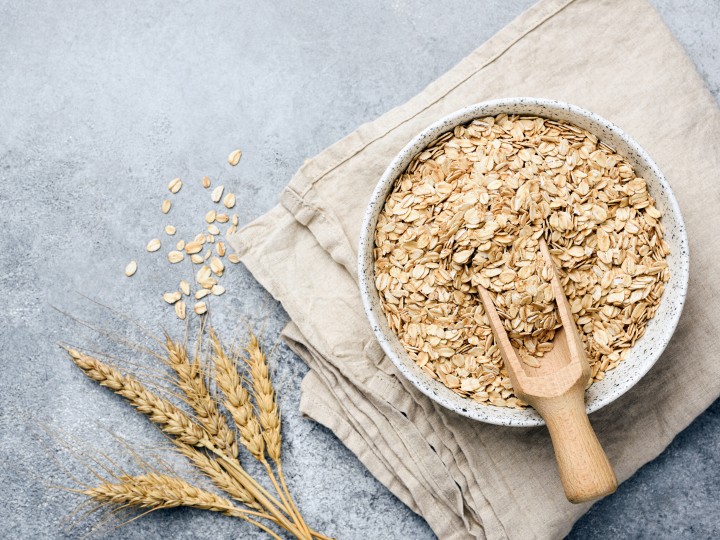 Oat flakes, oats or rolled oats in bowl. Table top view