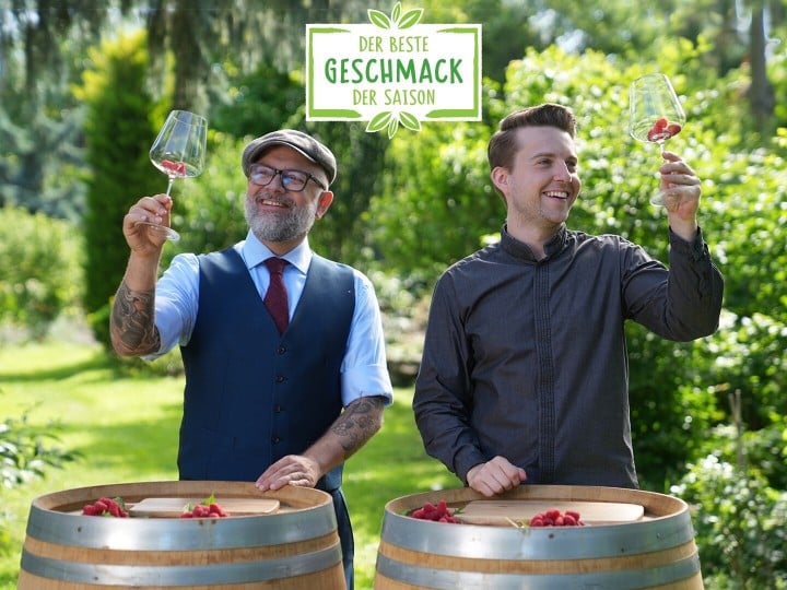 Hier sieht man zwei Sommeliers die Himbeeren in Weinglas schwenken