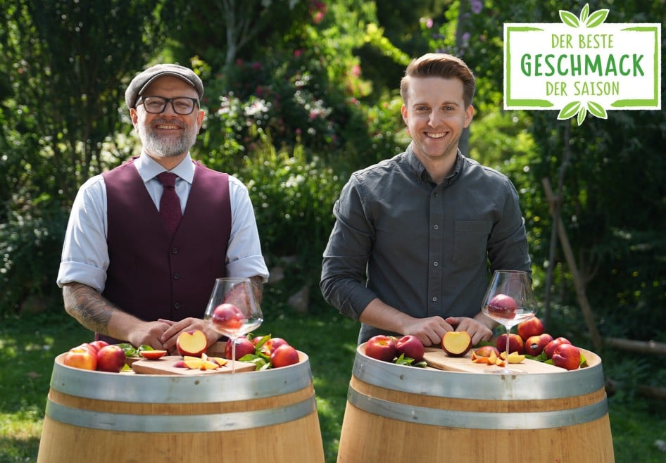 Hier sieht man zwei Sommeliers die sich gegenseitig zuprosten und die Nektarinen in den Weingläsern betrachten