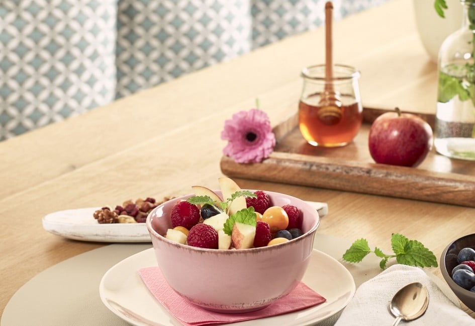 Frühstückstisch gedeckt mit Porridge und Früchten