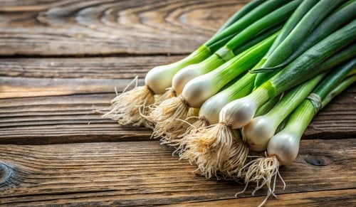 Fresh spring onions on wooden background