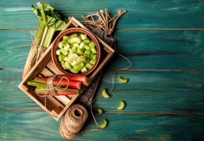 Rhubarb stalks on a board, Rhubarb in bowl on a wooden background. Rhubarb stalks on a board, Rhubarb in bowl on a wooden background. top view.