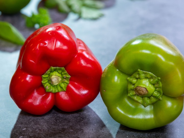 Grüne und Rote Paprika, Frisches Gartengemüse im Hintergrund  