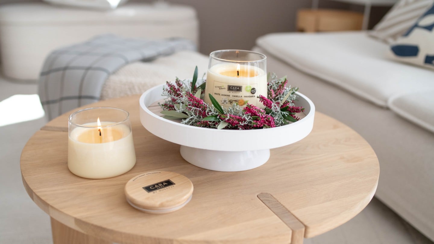 Cara Home Kerzen, dekoriert auf einem kleinen Tisch im Wohnzimmer