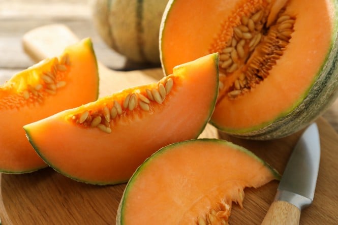 Cantaloupe  aufgeschnitten neben einem Messer am Tisch